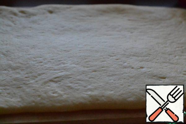 After 12-14 hours, put the dough out of the refrigerator on a cutting Board and prepare the filling.