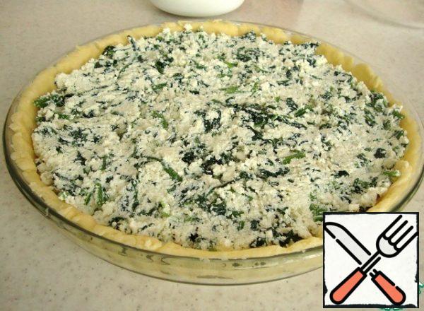 Grease the form with oil, I have a glass one with a diameter of 26 cm.
Roll out the cooled dough thinly, about 3-5 mm, and put it in the form.
Put the curd and cheese mass on the dough.