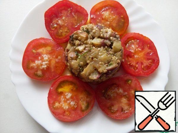 Wash the tomatoes, dry them and cut them into slices.
Arrange them around the eggplant and pour the remaining dressing over them.