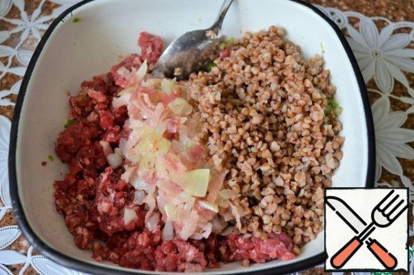 Fry the onion in vegetable oil, add pieces of bacon, fry and put everything to the mince, add buckwheat porridge, salt. Stir