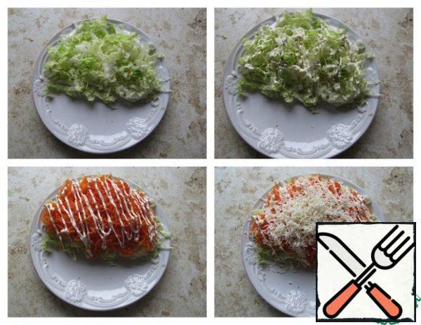 To prepare the salad, wash the leaves of Peking cabbage, cut into strips, mix with garlic (the amount to taste), sprinkle lightly with salt and herbs from the mill. Apply the thinnest grid of mayonnaise, top with a layer of grated carrots on a medium grater, the thinnest grid of mayonnaise, top with a layer of grated cheese, if desired, add thin slices of tomato. This salad requires garlic and mayonnaise, without these ingredients, the taste is lost!