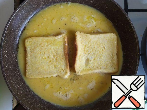 Pour the eggs into the pan and place two slices of bread, first dipping them on both sides. Cook for a couple of minutes.