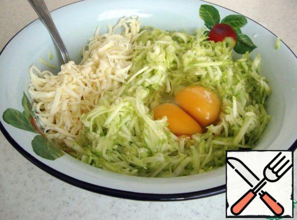 In a Cup, combine the zucchini, eggs and cheese.