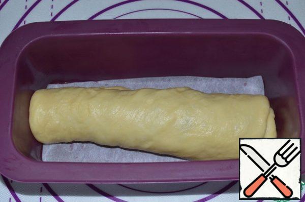 Roll up the roll and place in a greased baking dish.
Cover the form with a film and place it in a warm place for 40-50 minutes.