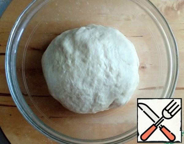Knead dough. I was kneading it in the bread maker. Then she put the dough in a bowl and covered it with cling film. Leave in a warm place for 30-40 minutes.