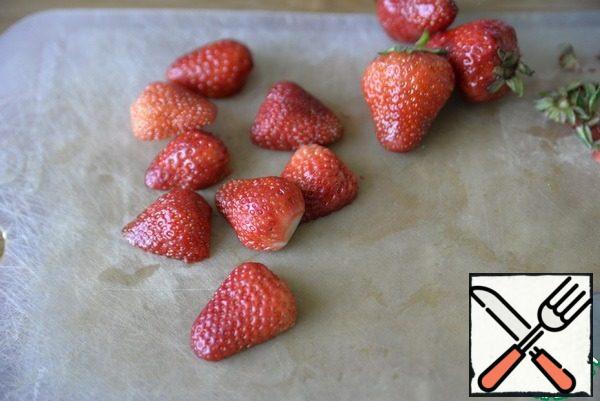Wash strawberries, slightly dry, cut off the tails. Cut it in half.