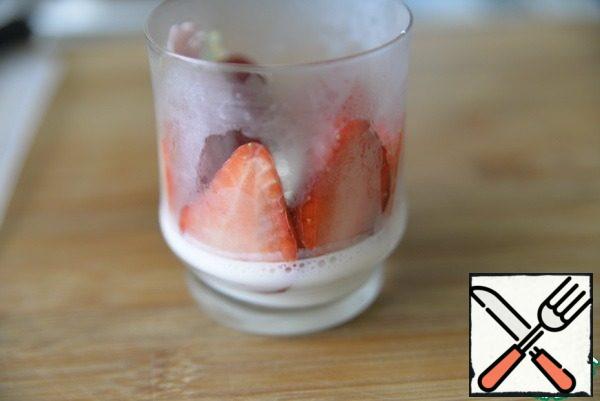 We take the glasses out of the freezer, put the strawberry halves on the jelly close to the wall of the glass. Lightly press the strawberries against the glass. Put it back in the freezer for 30 minutes. We need the strawberries frozen to the glass, so that the yogurt mousse does not seep through the strawberries. I took out the glasses twice in 30 minutes and pressed the strawberries against the glass.