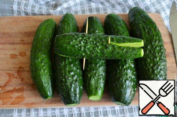 Wash the cucumbers and cut them in opposite directions on both sides.
So the faster they are salted, remaining as it were, intact.