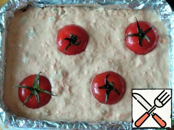 Pour the remaining batter on top. Distribute the cherry tomatoes. I have the usual small tomatoes, which I cut in half lengthwise and decorated with tops.