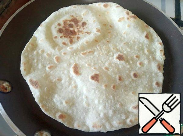 Roll out a piece of dough on the diameter of our pan. Bake the pita bread in a dry pan until Golden on both sides.