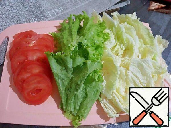 From the leaves of Peking cabbage, cut off the hard part. Cut the tomatoes into thin circles.