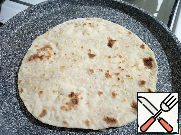 Grease the pan with vegetable oil and heat it up. Spread the pita bread with minced meat side down and fry for a few minutes, without closing the pan.