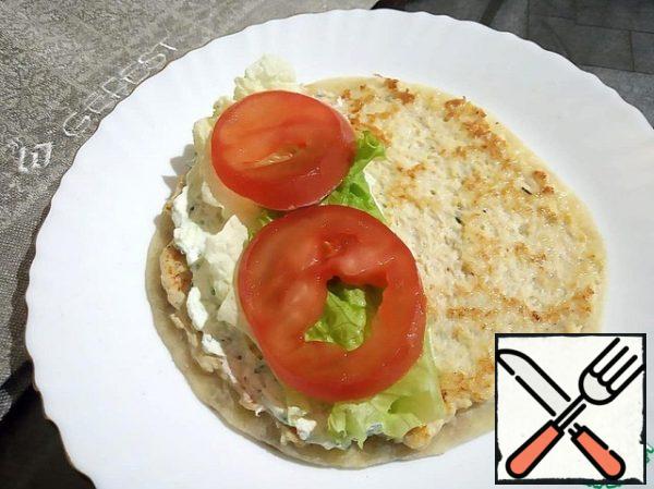 Spread the tomatoes on top and cover with the second half of the pita bread.