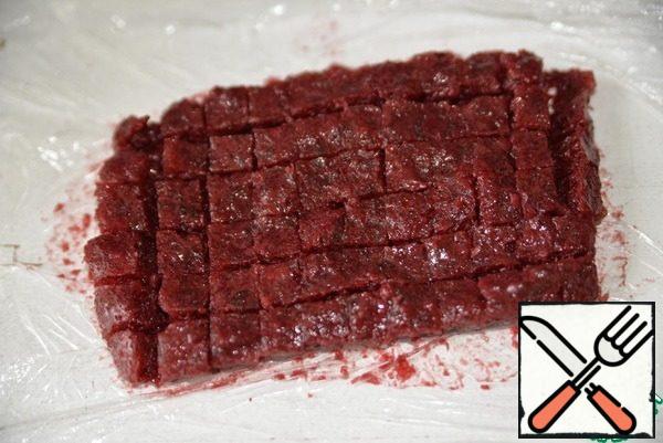 Frozen cherry jelly is taken out of the refrigerator, cut into cubes.