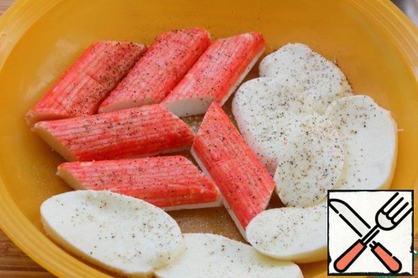 Cut the mozzarella (if large), lay out the crab sticks.
Season with salt and pepper.