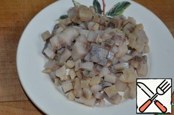 Cut the herring fillet into cubes.
