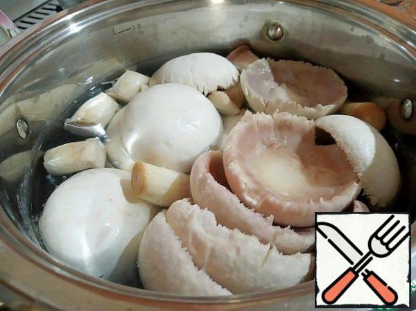 Mushrooms are cleaned from the skin and dark plates under the cap. Carefully separate the leg. And send the hats and legs to boiling water for 1 minute. Then we drain the water and wash it with running water.