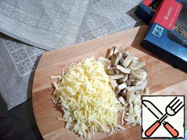 Legs of mushrooms are cut into small blocks. Grate the cheese on a large grater. Chop the garlic. Add all this to the Turkey, salt to taste and mix thoroughly.