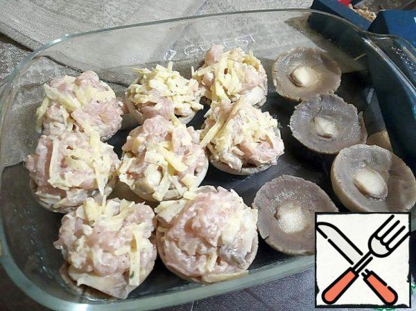 The container for singing is greased with vegetable oil. We put the caps of mushrooms in it and fill it with Turkey and cheese. Close the form with mushrooms with foil and send it to the preheated oven (200 degrees) for 15 minutes. Then remove the foil and bring to a ruddy state (it took me 15 minutes).
