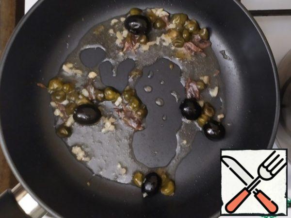 Heat a couple of tablespoons of olive oil. Fry the garlic. Add the chopped anchovy fillets and fry for 1-2 minutes. Add olives, capers, chili.

The fragrance is amazing...