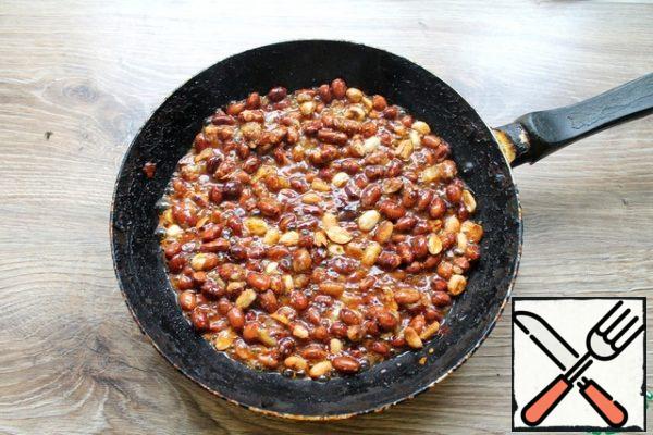 While the gelatin swells, make a praline. Put the nuts in the pan and put them on medium heat and fry a little. Then pour in the sugar, add the fire and will, stirring, heat until the sugar dissolves and turns it into caramel.