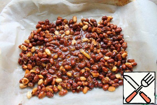 Cover the baking sheet with baking paper, brush with butter and transfer the nuts to the caramel, flatten. Remove to cool in a cool place.