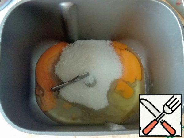 To start, prepare the dough. I'll mix it in the bread maker. To do this, combine the eggs with sugar.