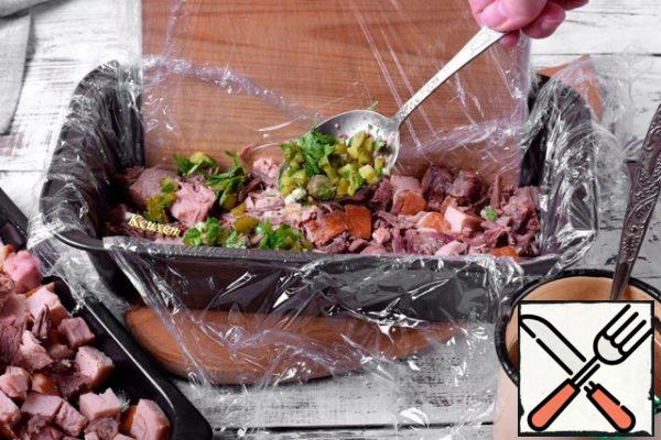 Next, lay out 1/3 of the green layer, evenly distributing it over the surface of the meat.