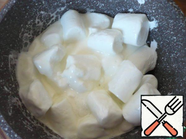 Warm the marshmallows in the microwave in short bursts. if there is no microwave, use a water bath. When the marshmallow starts to heat, pour in the rich cream (95 ml). And again, warm up the mass a little. Mix it carefully each time.