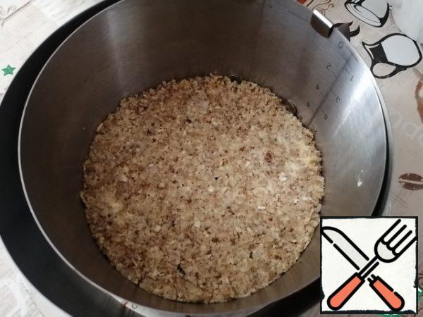 Place a baking ring on the dish and lay out the base of the resulting mass. Put it in the refrigerator for 1 hour