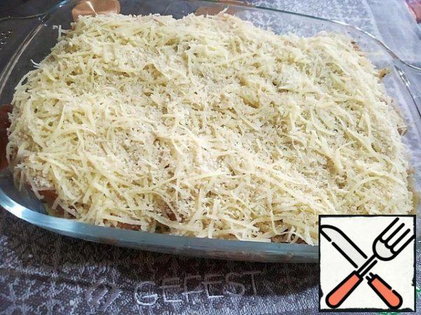 Grate the cheese on a fine grater. Add breadcrumbs to half of the grated cheese and mix. Evenly cover the chicken fillet with this mixture.