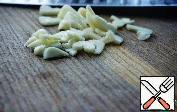 Garlic is cleaned and cut into plates.