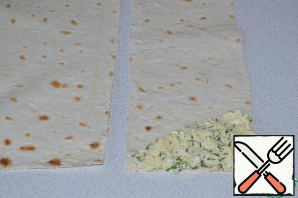 Cut the pita bread into strips measuring 10 by 30 cm.
Spread on one corner strips about 1.5 tbsp of the filling.