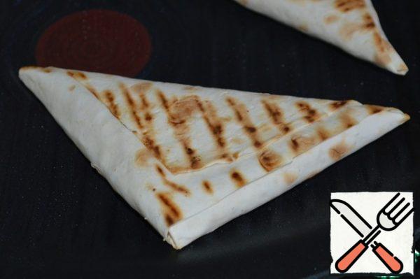 Preheat the grill pan and grease it with vegetable oil using a cooking brush or spray. Put the pita triangles on a preheated grill pan and fry on both sides.