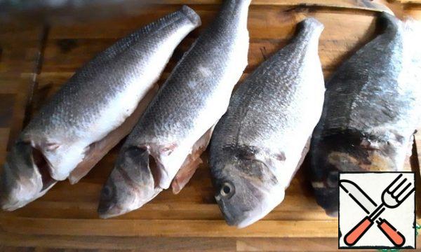 While the potatoes are cooking, prepare the fish.
I have two Dorado and two sea bass, and you can take mackerel.
Cut off all the fins, pull out the gills, remove the scales.