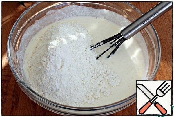 Then add the flour and baking powder,
mix everything well.
The dough should be slightly thinner than on pancakes, but a little thicker than on pancakes.
If you use baking soda instead of baking powder, then you do not need to extinguish it, the fermented milk product will perfectly cope with this itself.