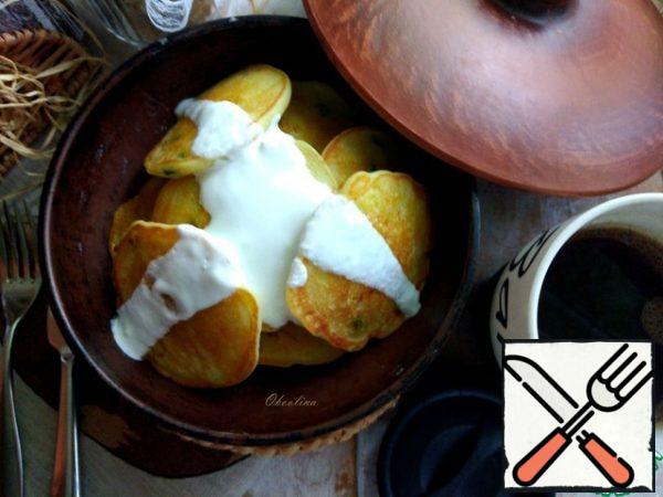 Served pancakes, watering them with natural yogurt.