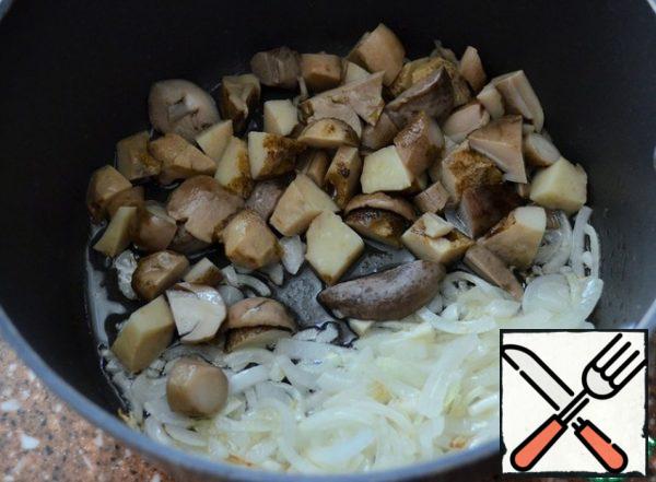 Boil the mushrooms on a sieve, use the broth for soup.
Fry the onion in vegetable oil and add the chopped mushrooms.