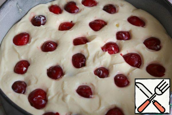 Add 5 g of starch to the cherries and mix.
Put half of the curd mixture in the form.
On it we spread half of the cherries, drowning the berries, again the curd layer and the remains of the cherries.