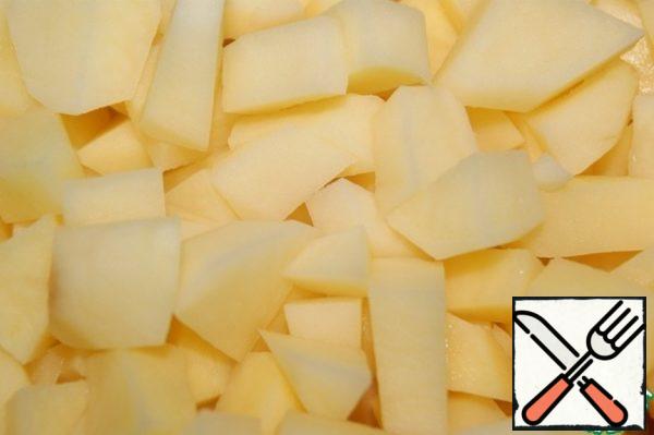 Prepare the broth. Cut the potatoes into small pieces and lower them into the boiling broth.