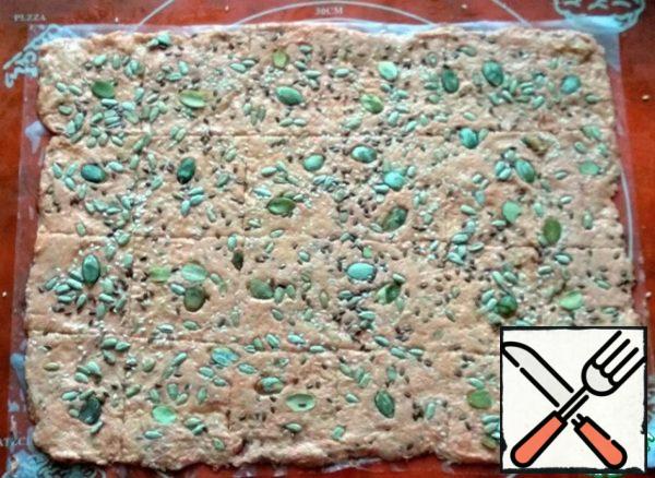 Sprinkle with sesame seeds (0.5 tbsp), flax seeds (0.5 tbsp), sunflower and pumpkin seeds. Roll again with a rolling pin to "drown" the seeds. Cook in the oven, preheated to 180 degrees, 15-20 min., no longer necessary, otherwise you can over-dry.