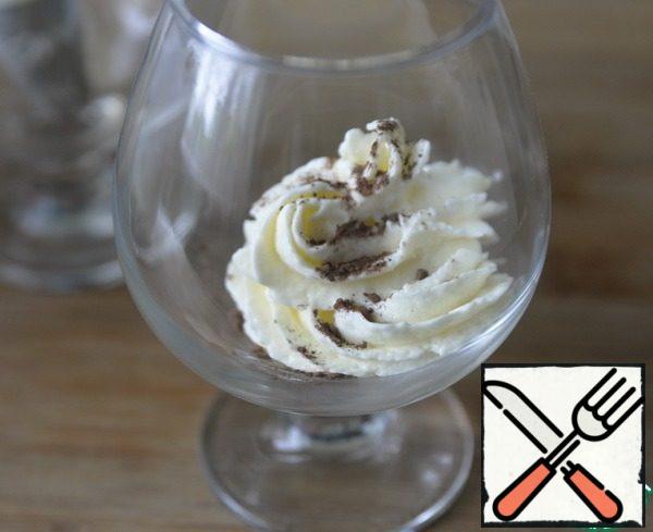 To serve, take glasses. For the convenience of dessert decoration, the cream was put in a cooking bag with a nozzle. At the bottom of the glass, put a little cream, sprinkle with cocoa powder.