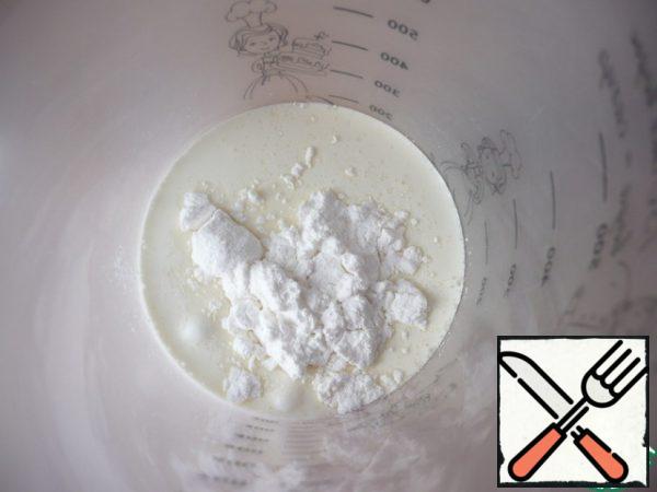 In another container, mix cold cream with 10 g of powdered sugar and beat with a mixer with a persistent cream.