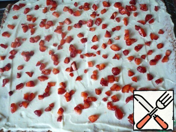 On top of the cream, put the chopped strawberries (scattering them over the entire surface).
