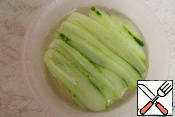 To make the brine. Mix water with salt, bring to a boil and dissolve the salt. Pour in the cucumbers, let cool at room temperature, and then refrigerate overnight..