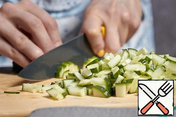 Chop the cucumbers into the same cubes as the potatoes.
