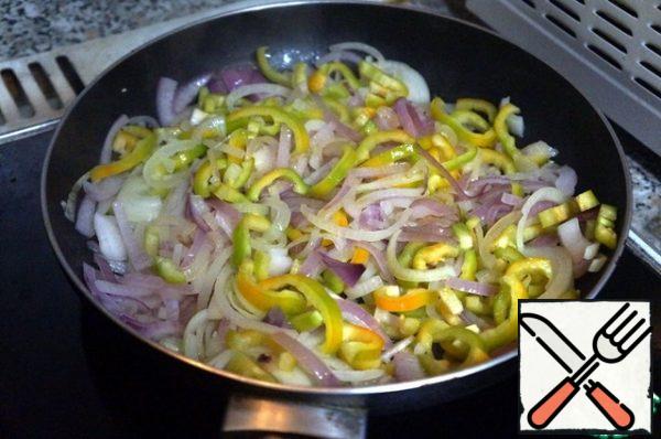 Add the pepper cut in half rings to the onion, stir, and fry for about 2 minutes.