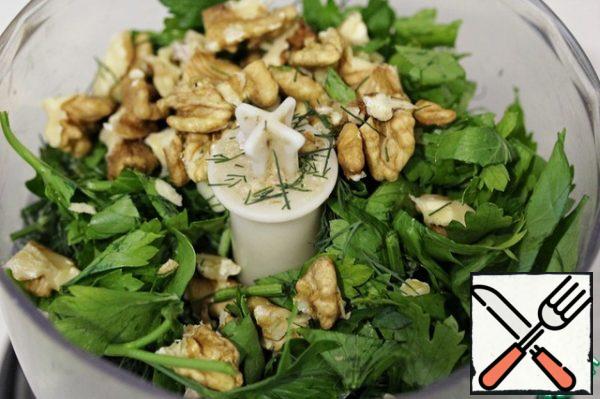 Put the dill, parsley, garlic and nuts in the bowl of a blender or food processor.