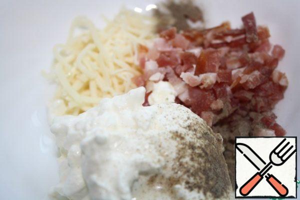 Mix the cheese, chopped bacon, and sour cream.
If sour cream is thick, then add milk, and if not, then you will not need milk.
Sprinkle with salt and pepper to taste.
Add the onion and mix well.