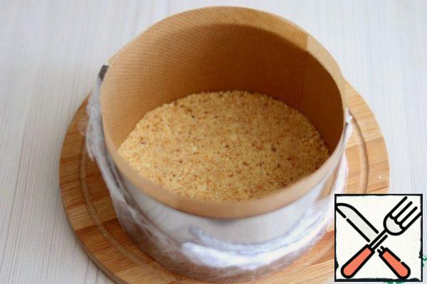 The bottom of the split mold is lined/tightened with food wrap. Put a small amount of sand base on the bottom of the mold. The layer of sand base is slightly rammed with a cooking pestle or spoon. Put the sliced apricot slices on the sand base, then add a small amount of yogurt base. Then again lay out the sand base. Distribute the sand base over the entire base of the form.